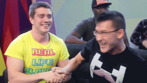 a man in a yellow shirt that says real life is shaking hands with another man
