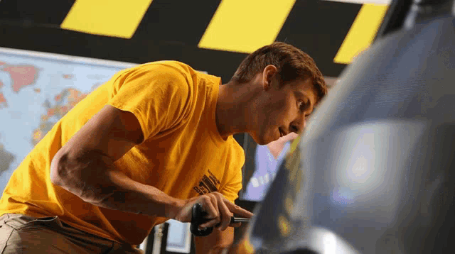 a man wearing a yellow shirt that says ' navy ' on it