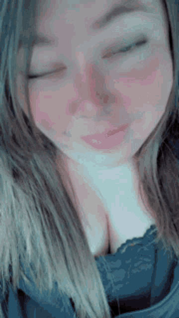 a woman with her eyes closed is wearing a black lace top