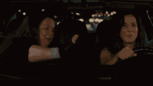 two women are fighting in a car with one screaming