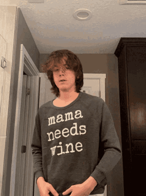 a boy wearing a mama needs wine sweatshirt