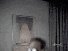 a man is standing in front of a mirror in a room .