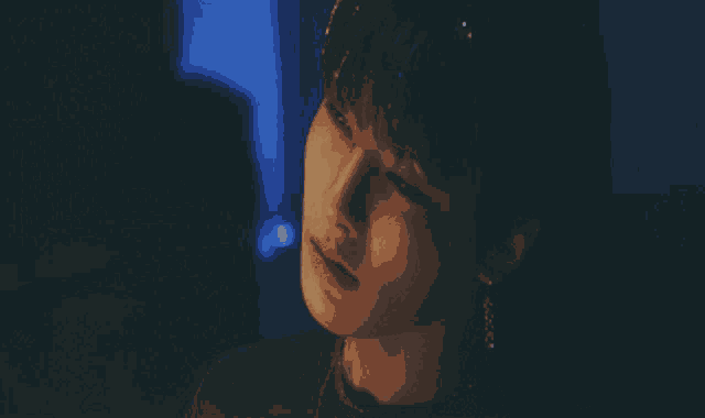 a close up of a person 's face with a blue background