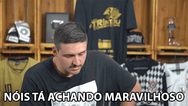 a man wearing a black shirt with the words noi is ta achando maravilhoso