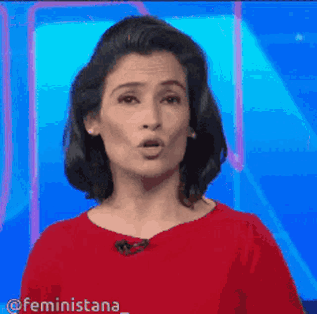 a woman in a red shirt is making a funny face on a blue background