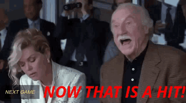 a man and a woman are watching a game with the words now that is a hit