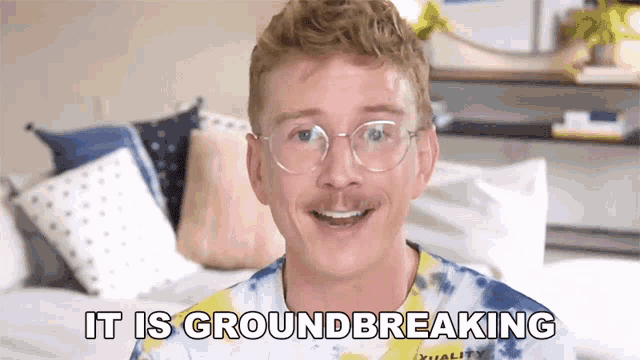 a man wearing glasses and a tie dye shirt says " it is groundbreaking "