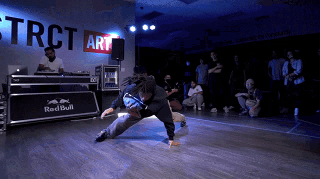 a man is dancing in front of a red bull sign