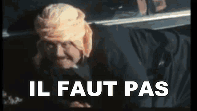 a man in a turban is laying in the back of a car with the words il faut pas written on the screen .