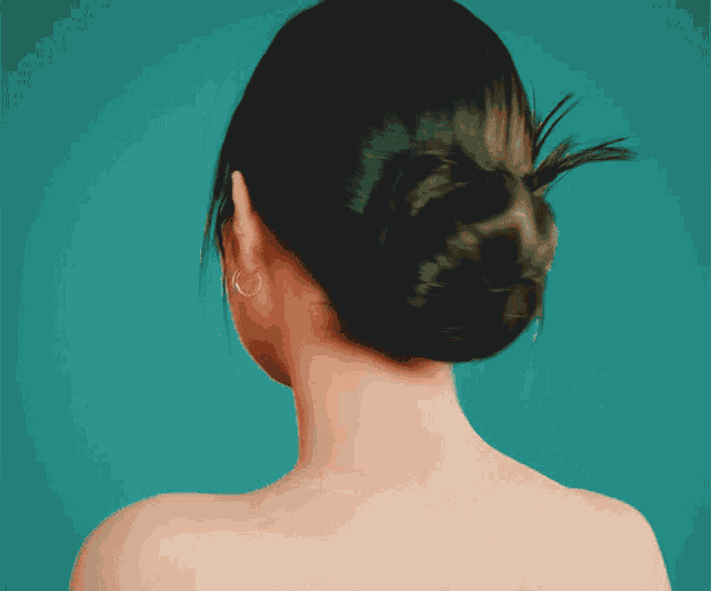 a woman 's back is shown with a bun on her hair