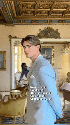 a man in a blue suit is standing in a room with the words noapte buna goodnight written on it