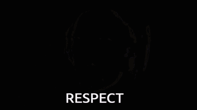 a man with a beard wearing headphones says respect in front of a microphone .