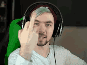 a man is wearing headphones and giving the middle finger .
