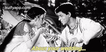 a black and white photo of a man and a woman holding hands and talking about their wedding .