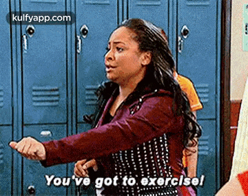 a woman is standing in front of a bunch of blue lockers and says `` you 've got to exercise ! ''