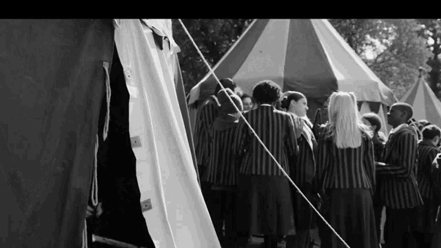 a black and white photo of a group of people in striped uniforms