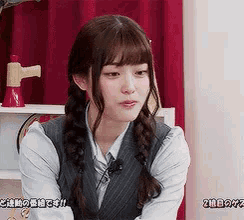 a girl with braids is wearing a vest and tie .