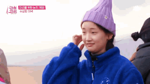 a young woman wearing a purple hat and a blue jacket