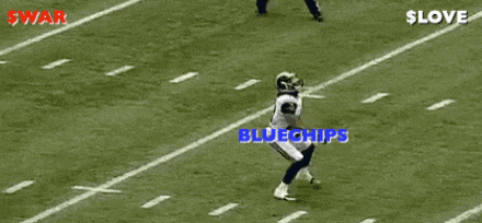 a football player is laying on the field while another player runs toward him .