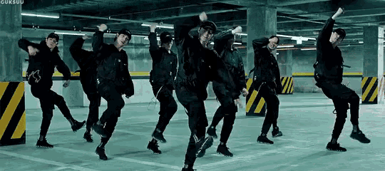 a group of people are dancing together in a parking garage .