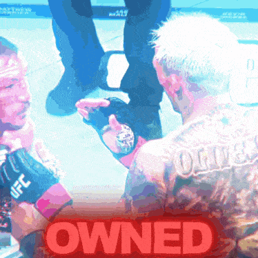 a man with a tattoo on his back is being held by another man with the word owned in red