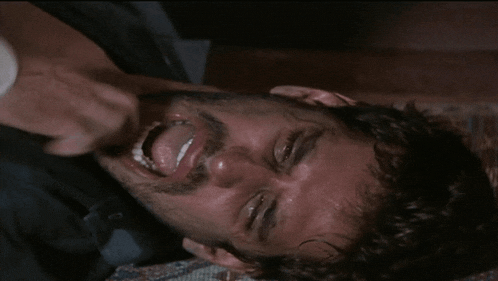 a man with his mouth open is being held by another man