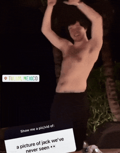 a shirtless man in tulum mexico is dancing with his arms in the air