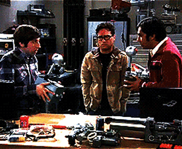 a group of men standing around a table with a laptop that says ctv