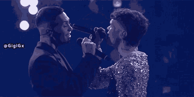 a man and a woman singing into microphones with the hashtag gigigx