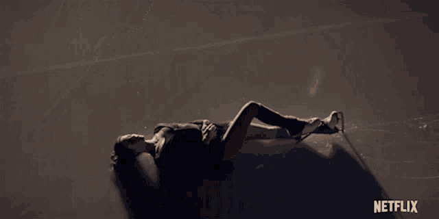 a woman is laying on a ice rink with a netflix logo in the corner
