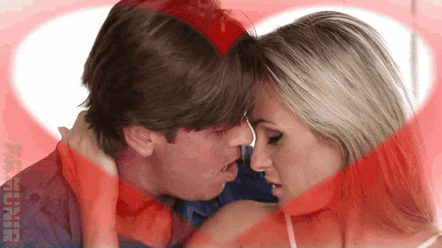 a man and a woman are kissing with a heart in the background and the word photographer is visible