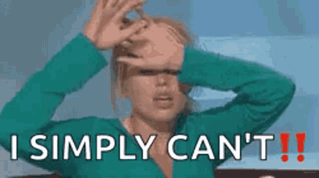 a woman in a green sweater is covering her face with her hands .