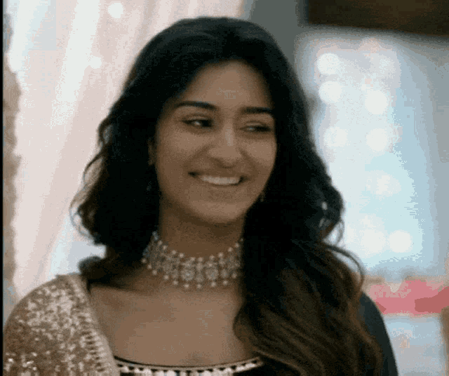 a woman wearing a choker is smiling and looking at the camera