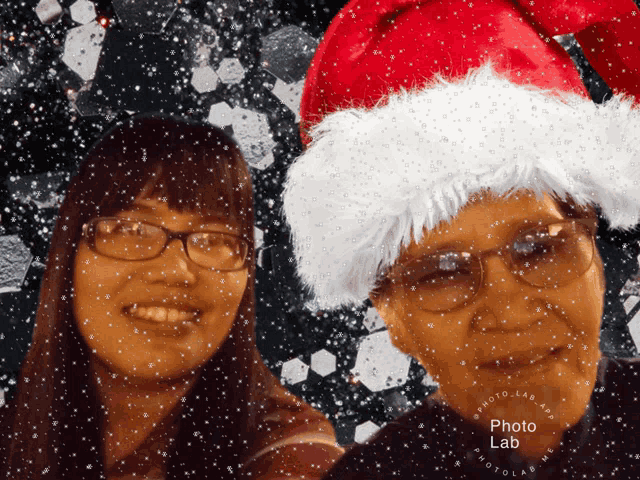 a woman and a man wearing santa hats with a photo lab logo in the corner