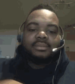 a man with a beard is wearing a headset and looking at the camera .