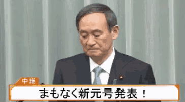 a man in a suit and tie is giving a speech in chinese