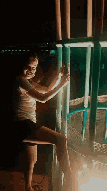 a woman in a white shirt and black shorts is standing on a trampoline