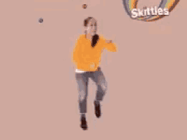 a girl is dancing in front of skittles candy
