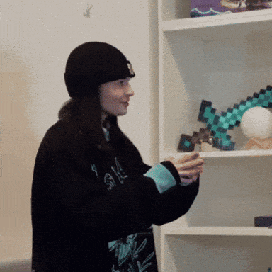 a woman standing in front of a shelf with a minecraft diamond axe on it