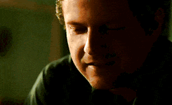 a close up of a man 's face with a green shirt on