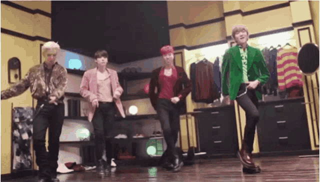 a group of men are dancing in a room with clothes hanging on the wall .