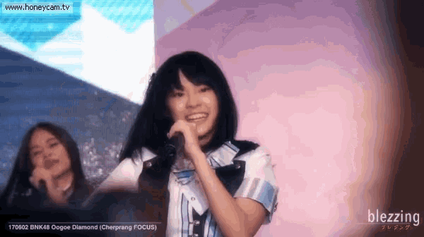a girl singing into a microphone with the website www.honeycam.tv visible in the background