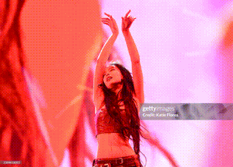 a woman is dancing with her arms in the air on a stage .