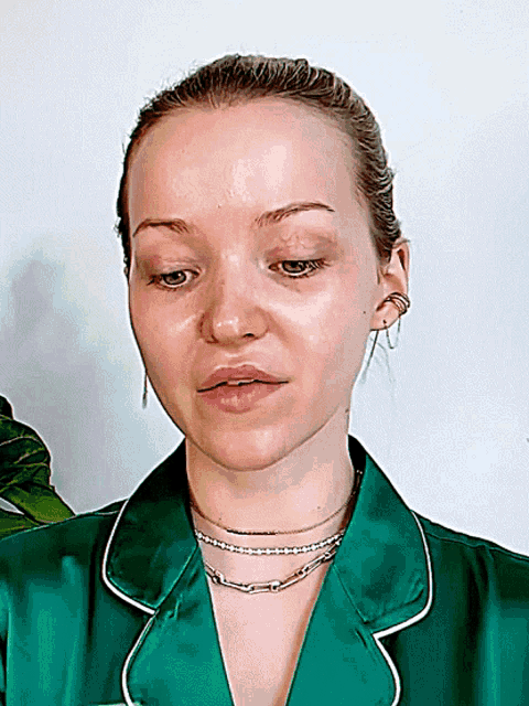 a close up of a woman 's face with a green shirt