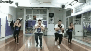 a group of people are dancing in a dance studio with the word dancise in the corner .