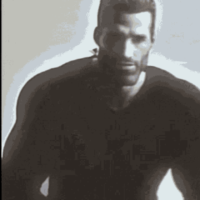 a man with a beard wearing a black shirt looks at the camera