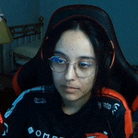 a woman wearing glasses and headphones is sitting in a chair looking at her phone .