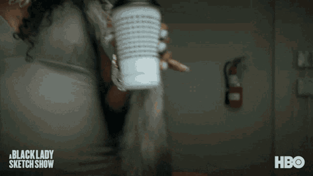 a woman is holding a cup of coffee in a scene from the black lady sketch show on hbo