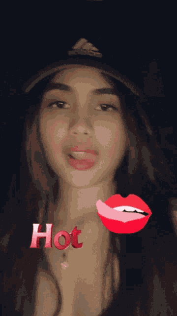 a woman wearing a hat and a necklace with the word hot on her chest