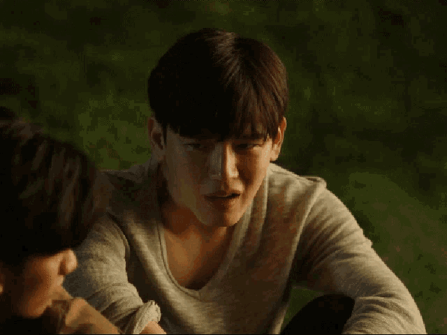 a man in a grey shirt is sitting next to a woman